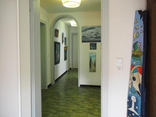 a hallway with an archway and paintings on the walls at Künstlerhaus Arthotel in Geislingen