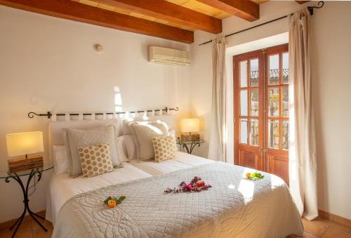 Un dormitorio con una gran cama blanca con fruta. en Hotel Apartament Sa Tanqueta De Fornalutx - Adults Only, en Fornalutx