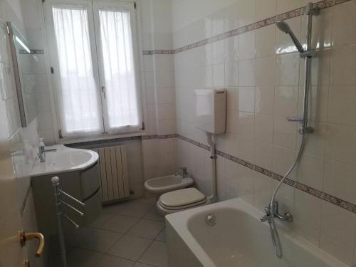 a bathroom with a tub and a toilet and a sink at La Casa di Rita in Faenza