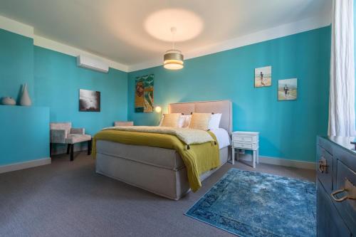 a bedroom with a bed and a blue wall at Château de Maumusson in Maumusson-Laguian