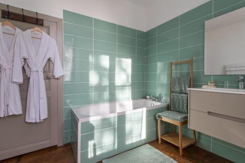 a bathroom with green tiles and a sink and a mirror at Château de Maumusson in Maumusson-Laguian