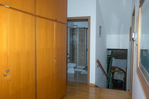 a bathroom with a toilet and a wooden door at Hotel Fiames in Cortina dʼAmpezzo