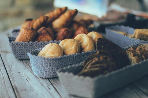 a table topped with baskets of different types of bread at B&B La Bouliniere in Malmedy
