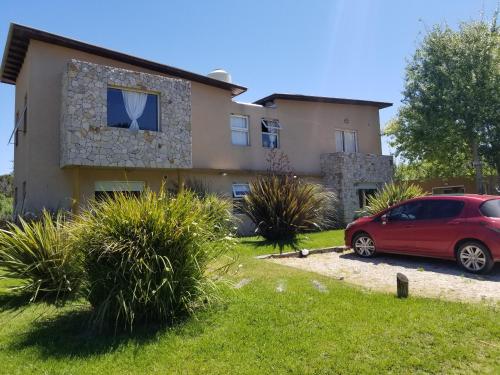 a house with a red car parked in front of it at Princesas Del Mar a 4 cuadras del mar in Mar Azul