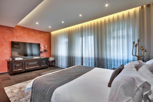 a bedroom with a large bed and a flat screen tv at U Collection - a Luxury Collection Suites, Valletta in Valletta