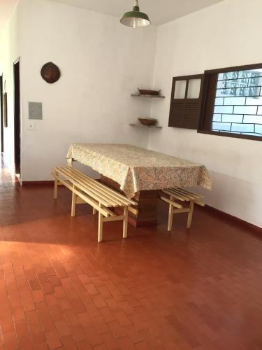 a table and two benches in a room at Casa da Dazinha in Guarapari