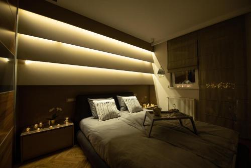 a bedroom with a bed with lights on the wall at Apartment NS Life in Novi Sad