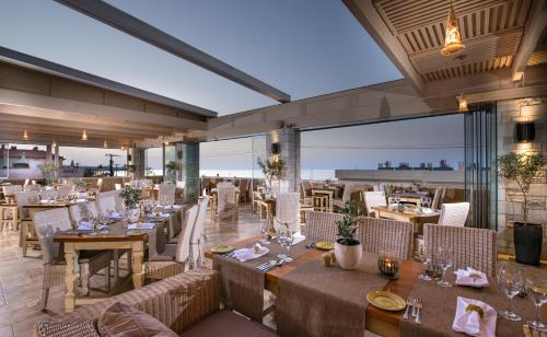 a restaurant with tables and chairs in a room at Cactus Royal Spa & Resort Adults Only in Stalida