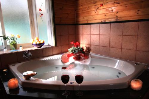 a bath tub with two glasses of wine in it at Batei Nurit in Moshav Ramot