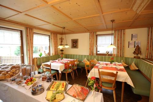 Un restaurante con mesas y sillas con comida. en Mein Landhaus, en Burgberg