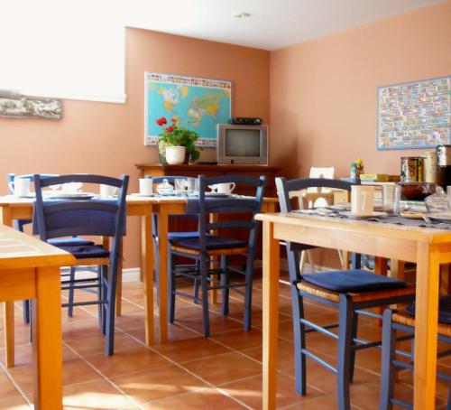 Un comedor con mesas y sillas y un televisor. en B&B La Bedondaine, en Quebec