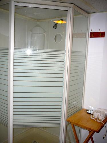 a glass shower door in a room with a table at B&B La Bedondaine in Quebec City