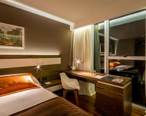 a hotel room with a desk and a bed and a bed and a desk at Yrigoyen 111 Hotel in Cordoba