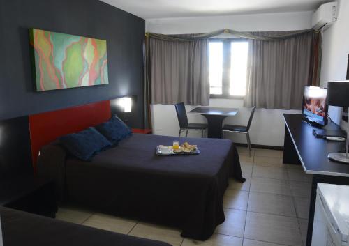 a hotel room with a bed and a table and chairs at Apart Hotel Alvear in Rosario
