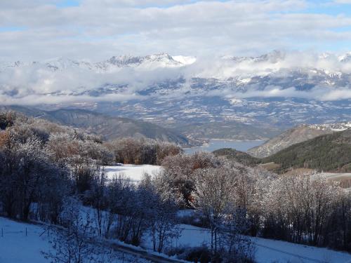 a view of a mountain range with snow covered mountains at Maison d'hôtes l'Arnica in La Bréole