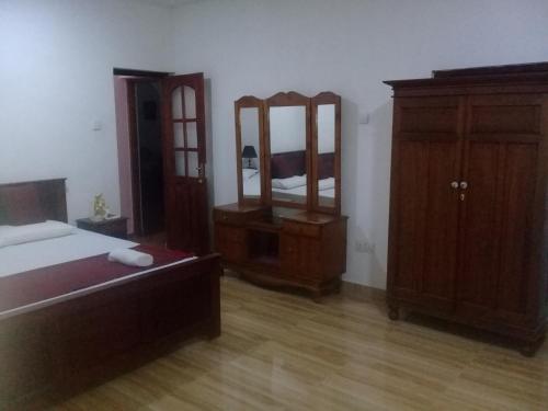 a bedroom with a bed and a dresser and mirror at Kuma Beach side Villa in Wadduwa