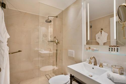 a bathroom with a tub, sink and mirror at Hotel Jacob Samuel by Prima Hotels in Tel Aviv