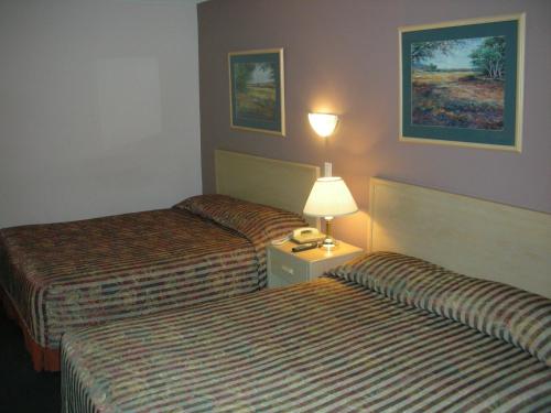 A bed or beds in a room at Cache Creek Inn
