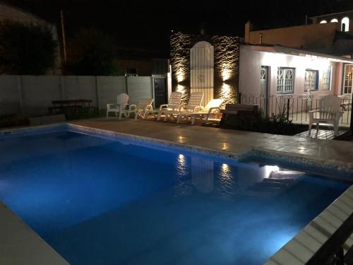 a swimming pool in front of a house at night at Hotel El Mirador in Chascomús