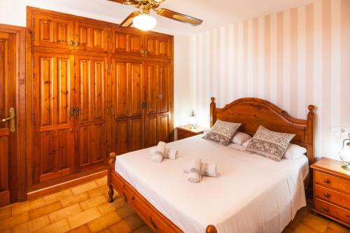 ベニッサにあるVillas Guzman - Garroferのベッドルーム1室(白いシーツと木製家具付きのベッド1台付)