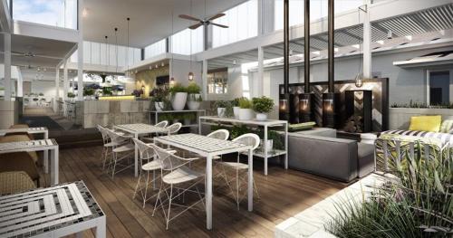 een restaurant met tafels en stoelen in een gebouw bij Cottesloe Beach Hotel in Perth