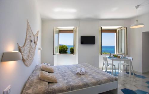 a bedroom with a bed and a dining room with a table at Ciutat Alghero in Alghero