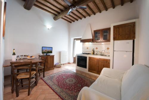 a kitchen and dining room with a table and a kitchen with a counter at Tenuta Decimo - Il Borgo Di Mariano in San Gimignano