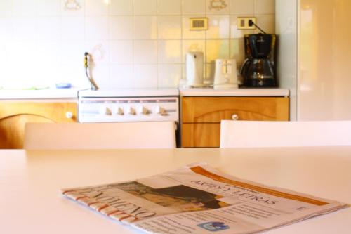 a kitchen with a newspaper on a table at Cabañas Playa Linda in Pucón