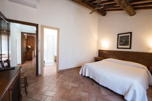 a bedroom with a white bed in a room at Tenuta Decimo - Il Borgo Di Mariano in San Gimignano