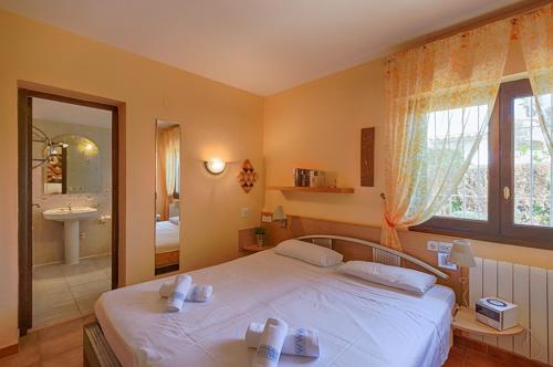 a bedroom with a large white bed and a bathroom at Villas Guzman - Kismet in Moraira