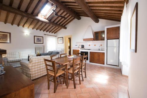a kitchen and living room with a wooden table and chairs at Tenuta Decimo - Il Borgo Di Mariano in San Gimignano
