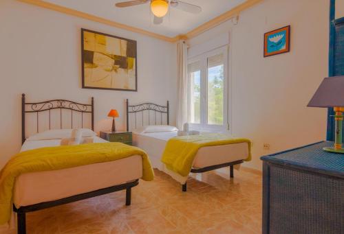 a bedroom with two beds and a window at Villas Guzman - Ifach in Calpe