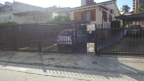 una cerca negra con un coche aparcado detrás de ella en complejo Casa Walter en Villa Carlos Paz