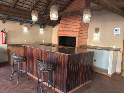 a bar with stools in a room with a fireplace at Bravo City Rondonópolis in Rondonópolis