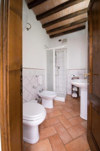 a bathroom with a toilet and two sinks at Tenuta Decimo - Il Borgo Di Mariano in San Gimignano