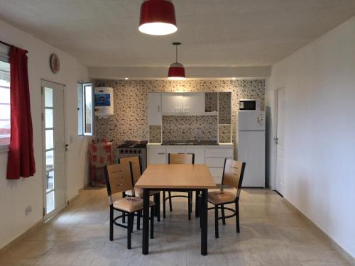 cocina y comedor con mesa y sillas en Azalá casa de playa en San Clemente del Tuyú