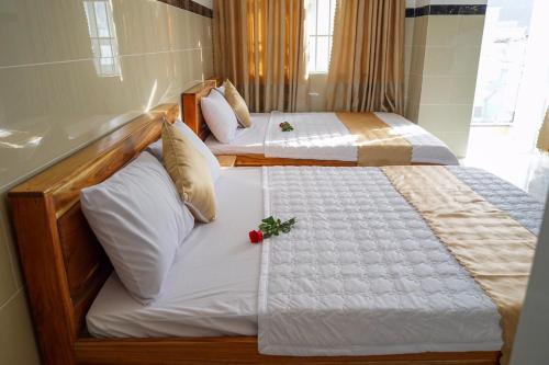 two twin beds in a room with one with a flower on it at Hotel Hoai Anh in Vung Tau