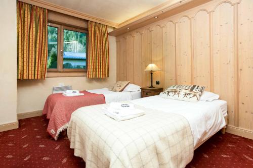 Chamois Apartment- Chamonix All Year في شامونيه مون بلان: غرفة فندقية بسريرين ونافذة