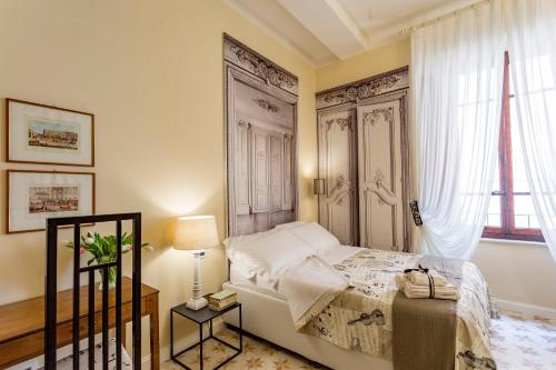 een slaapkamer met een bed en een groot raam bij Perle d'Ambra in Lucca