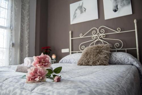 a bedroom with a white bed with pink flowers on it at Casa Rural Miradas De Aracena in Aracena