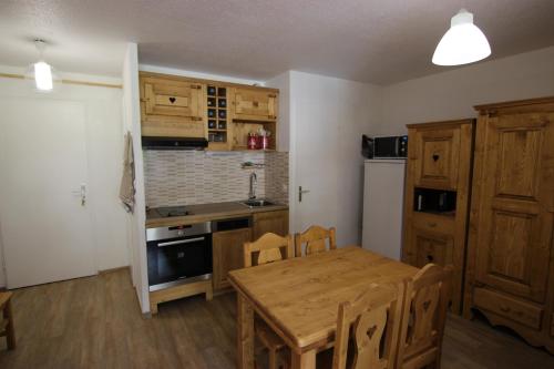 a kitchen with a wooden table and a dining room at Altineige Appartements VTI in Val Thorens