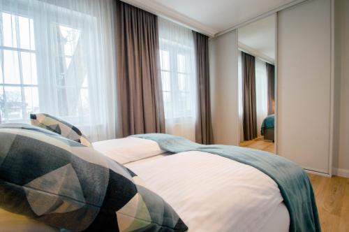 a bedroom with two beds in a room with windows at Grand Apartments - Willa Sobieski in Sopot