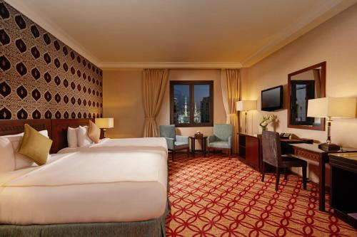 a hotel room with a bed and a desk at Dallah Taibah Hotel in Al Madinah