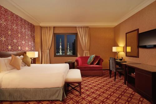 a hotel room with a bed and a desk at Dallah Taibah Hotel in Al Madinah