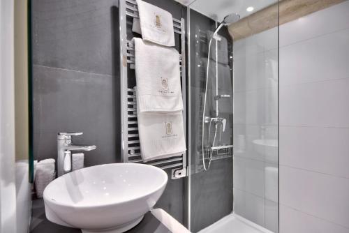a bathroom with a white sink and a shower at U Collection - a Luxury Collection Suites, Valletta in Valletta