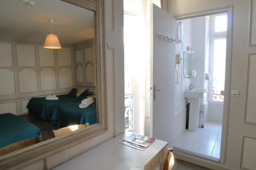 um espelho num quarto com uma cama e uma casa de banho em Au Fin Gourmet em Le Croisic