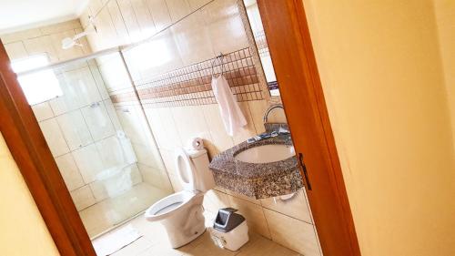 a small bathroom with a toilet and a sink at Chalé Alto da Serra SP in Serra Negra