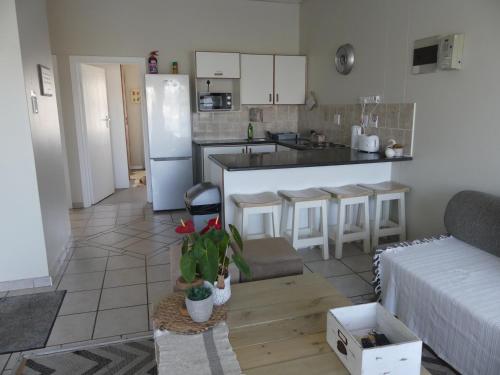 a kitchen and a living room with a white refrigerator at Rose and Ale Self Catering Units in Gonubie