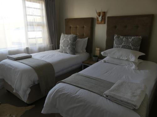 a bedroom with two beds and a window at Rose and Ale Self Catering Units in Gonubie