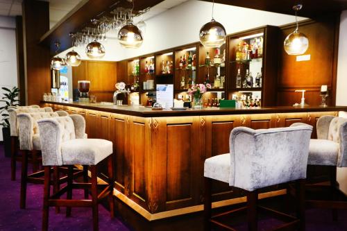a bar with a row of bar stools at Best Western Plus Hotel Olsztyn Old Town in Olsztyn